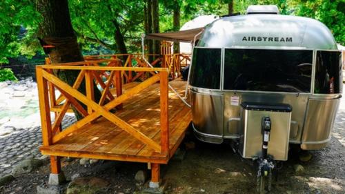 una cabaña estacionada junto a una terraza de madera en Riverside Glamping Nuts - Vacation STAY 84737v, en Komono