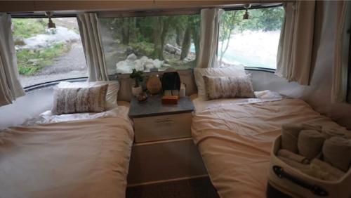 2 Betten in einem kleinen Zimmer mit Fenster in der Unterkunft Riverside Glamping Nuts - Vacation STAY 84737v in Komono