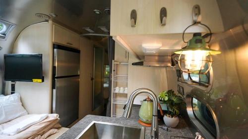 a kitchen with a sink next to a kitchen with a couch at Riverside Glamping Nuts - Vacation STAY 84737v in Komono