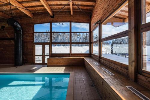 a swimming pool in a building with a large window at Charmant appartement 2 Pièces Cabine 4-6 Personnes in Chamrousse