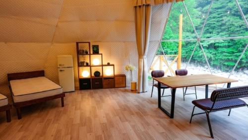 Habitación con mesa, sillas y ventana grande. en Riverside Glamping Nuts - Vacation STAY 84738v en Komono