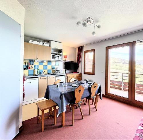 une cuisine avec une table et des chaises dans une pièce dans l'établissement Résidence Pistes - Appartement PMR 6 pers Magnifique Vue Vallee MAE-1254, à Villarembert