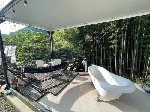 a bathroom with a tub and a hammock on a deck at The Basecamp Yugawara - Vacation STAY 84743v in Miyakami