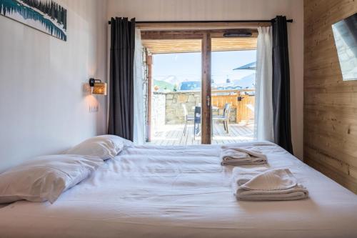 a bed with towels on it in a room with a window at Résidence Les Gentianes - Pièces 394 in LʼHuez