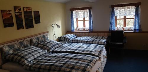 1 dormitorio con 2 camas y 2 ventanas en Chalupa Jestřebí, en Velké Svatoňovice