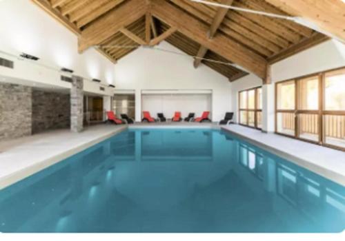 une piscine intérieure d'eau bleue dans un bâtiment dans l'établissement Résidence Le Chalet des Rennes - maeva Home - Appartement 2 pièces 4 personnes - Sélection MAE-4224, à Vars