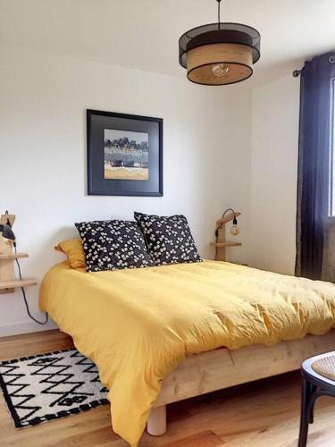 - une chambre avec un lit jaune et des oreillers dans l'établissement Jolie maison mesquéraise avec jardin proche mer, à Mesquer