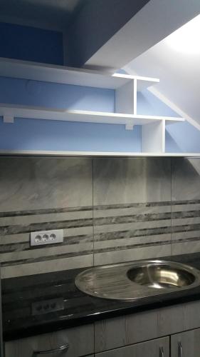 a kitchen with a sink and blue shelves at Lux apartment A5 at nice location in Pancevo in Pančevo