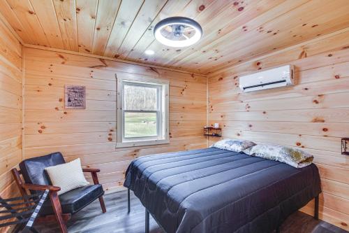 - une chambre avec un lit dans une cabane en bois dans l'établissement Modern Salineville Cabin on 13 Acres with Fire Pit!, 