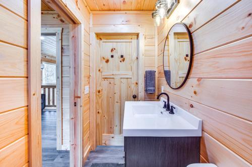 La salle de bains est pourvue d'un lavabo et d'un miroir. dans l'établissement Modern Salineville Cabin on 13 Acres with Fire Pit!, 