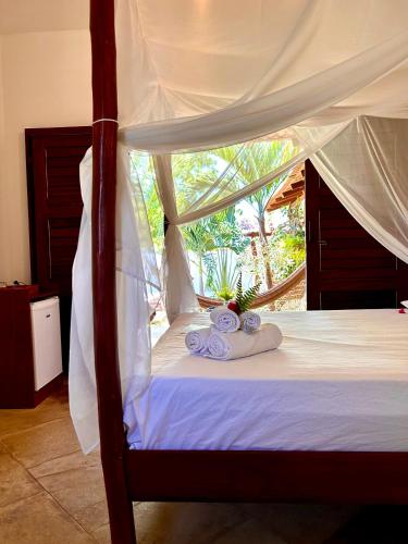 a bedroom with a canopy bed with towels on it at Villa Corsica in Prea