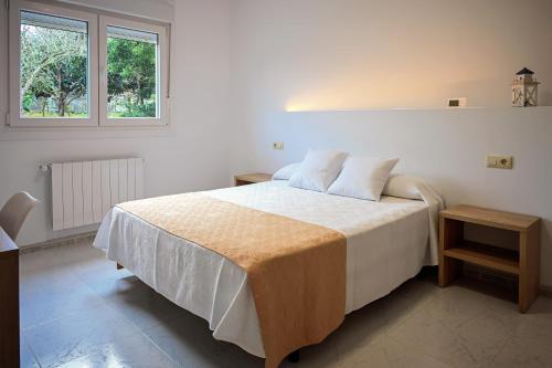 a white bedroom with a bed and a window at Apartamentos Costas de Bueu A in Bueu