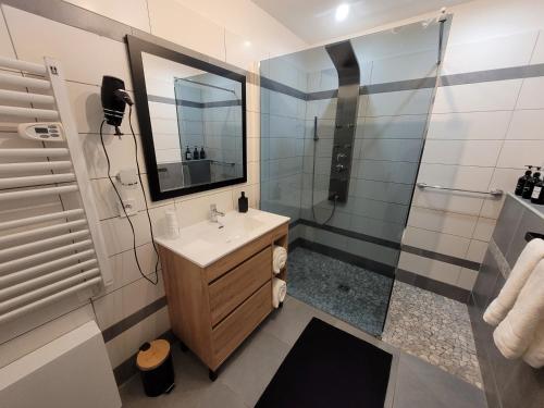 une salle de bain avec un lavabo et une douche dans l'établissement L'instant des Plaisirs, à Héming