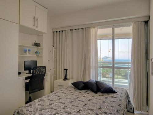 1 dormitorio con cama y ventana con vistas en LINKHOUSE LUXURY BEACHFRONT FLATS, en Río de Janeiro
