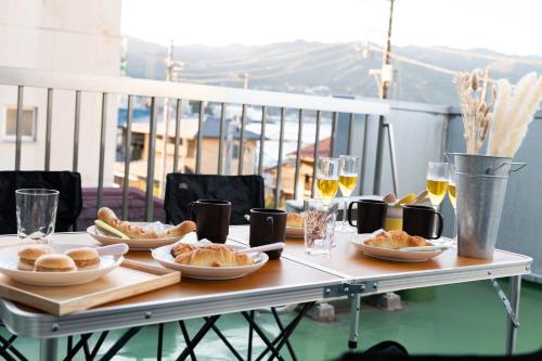einen Tisch mit Teller mit Speisen und Gläsern Wein in der Unterkunft Atami-Ajironokaze - Vacation STAY 87959v in Atami