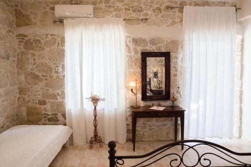 a bedroom with a bed and a mirror and a table at Villa Agapi 2 in Kamilari