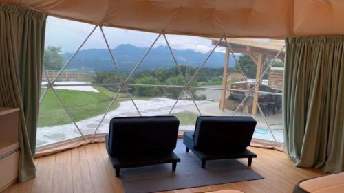 dwa krzesła w pokoju z dużym oknem w obiekcie Basecamp Haru - Vacation STAY 91967v w mieście Shibukawa