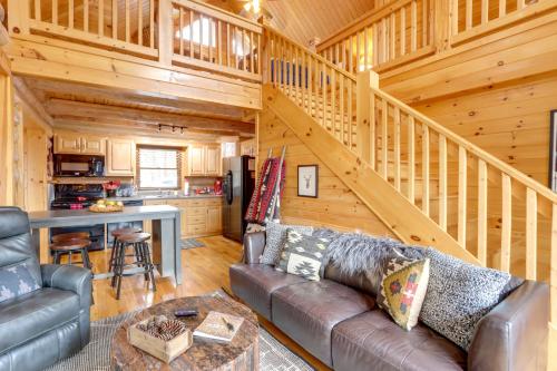 a living room with a couch and a staircase at Blue Ridge Log Cabin with Hot Tub and Game Room! in Blue Ridge