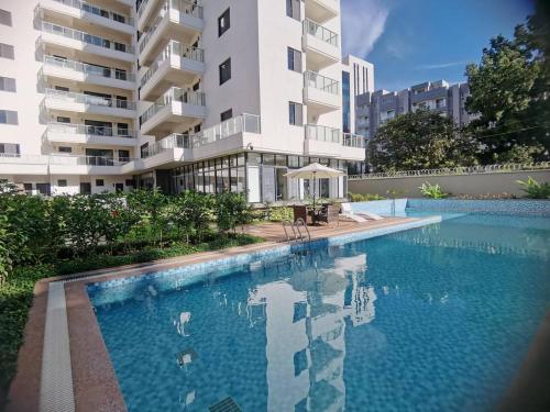 a swimming pool in front of a building at City One Apartments Kololo in Kampala