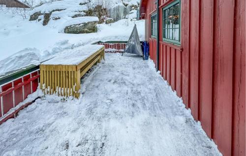 um passeio coberto de neve ao lado de um edifício vermelho em Awesome Home In seral With Wifi em Åseral