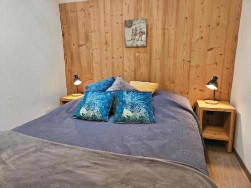 ein Schlafzimmer mit einem Bett mit zwei Kissen darauf in der Unterkunft Gîte BLEUET le petit LOFT, dans résidence et SPA in Ventron