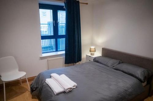 een slaapkamer met een bed met twee handdoeken erop bij 1-Bed Flat in Ocean Village in Southampton