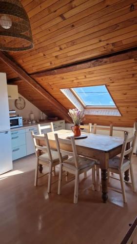 une cuisine avec une table et des chaises dans une pièce dans l'établissement Maison atypique au grand charme, à Embrun