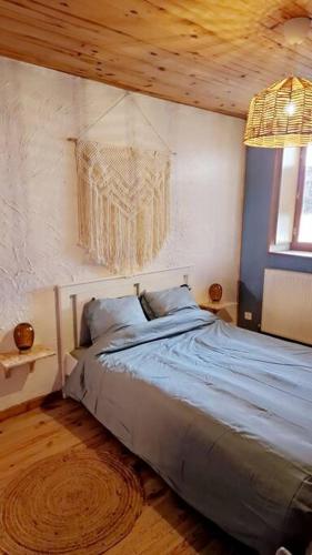 Schlafzimmer mit einem Bett mit Holzdecke in der Unterkunft Maison atypique au grand charme in Embrun