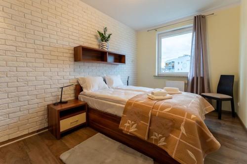 a bedroom with a bed and a brick wall at Apartament Rodzinny dla 6 osób - funkcjonalny - Space Apart in Jelenia Góra