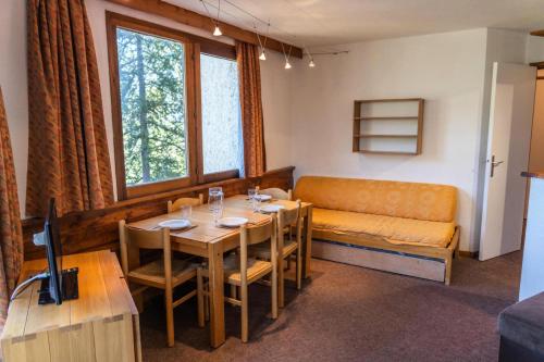une salle à manger avec une table et un canapé dans l'établissement Résidence Le Belvedere - Appartement 2 pièces au coeur des Orres 1650 MAE-6294, aux Orres