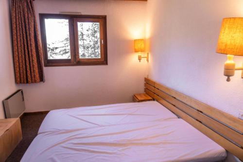 une chambre avec un lit blanc avec une fenêtre dans l'établissement Résidence Le Belvedere - Appartement 2 pièces au coeur des Orres 1650 MAE-6294, aux Orres