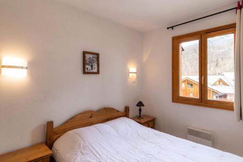 une chambre avec un lit blanc et une fenêtre dans l'établissement Résidence Le Balcon Des Airelles - Appartement calme au cœur des Orres 1800 MAE-6334, aux Orres