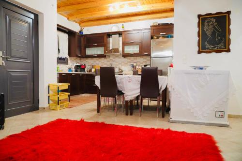 uma cozinha com uma mesa com cadeiras e um tapete vermelho em Villa Athamanio - Suite em Athamanio