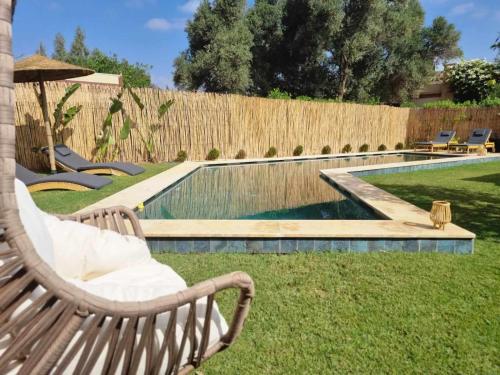 a garden with a bench and a swimming pool at Villa Naya et sa Piscine chauffée sans vis-à-vis in Agadir