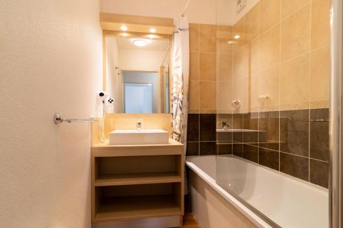 une salle de bain avec un lavabo, une baignoire et un miroir dans l'établissement Résidence Les Terrasses Du Soleil D'or - Agréable appartement au pied des pistes MAE-6394, aux Orres