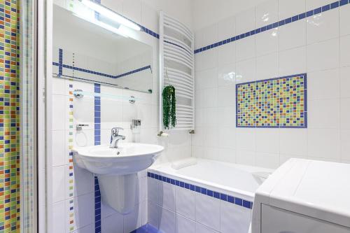 a white bathroom with a sink and a bath tub at Royal Apartment by Charles Bridge view of Saint Nicholas Church in Prague