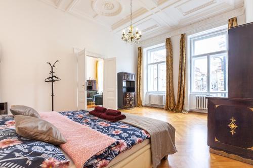 1 dormitorio con 1 cama grande en una habitación con ventanas en Royal Apartment by Charles Bridge view of Saint Nicholas Church, en Praga