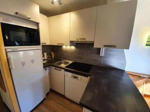 a kitchen with a white refrigerator and a sink at Résidence Le Belvedere - Studio coin montagne au coeur des Orres 1650 MAE-6554 in Les Orres