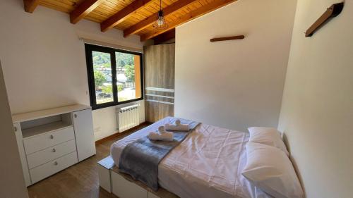 a bedroom with a bed and a window at Loretta - Sumando Latitudes in San Martín de los Andes