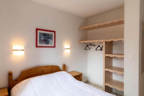 a bedroom with a bed and a book shelf at Résidence Le Balcon Des Airelles - 2 Pièces pour 4 Personnes 574 in Les Orres