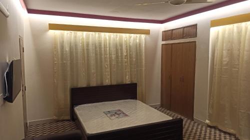 a small room with a bed and a closet at Signature Home in Dhaka