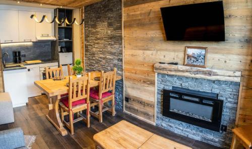 une salle à manger avec une table et une cheminée dans l'établissement Résidence Le Balcon Des Airelles - Superbe appartement aux Orres 1800 MAE-6714, aux Orres