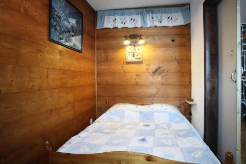 1 dormitorio pequeño con 1 cama en una pared de madera en Résidence Les Cembros - 2 Pièces pour 6 Personnes 971 en Les Orres