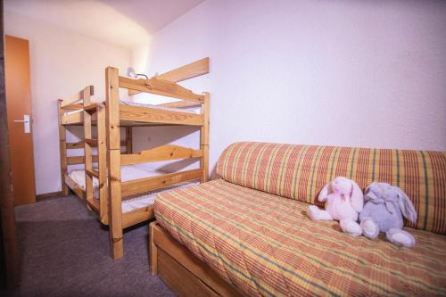 - un canapé avec des animaux farcis assis à côté d'un lit superposé dans l'établissement Résidence Le Belvedere - Studio coin nuit au coeur des Orres 1650 MAE-6724, aux Orres