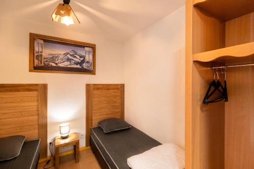 une petite chambre avec un lit et un placard dans l'établissement Résidence Le Parc Des Airelles - Studio 4 personnes avec vue sur les pistes MAE-6684, aux Orres
