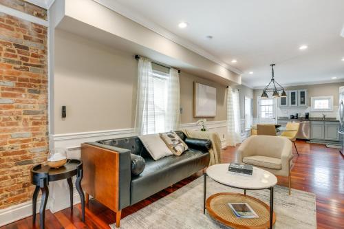 a living room with a couch and a brick wall at Charming Baltimore Getaway about 1 Mi to Downtown! in Baltimore