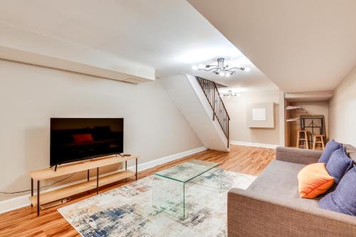 a living room with a couch and a flat screen tv at Charming Baltimore Getaway about 1 Mi to Downtown! in Baltimore
