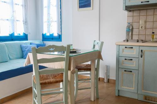 cocina con mesa, mesa y sillas en Vicky's Studios, en Órmos Aiyialís