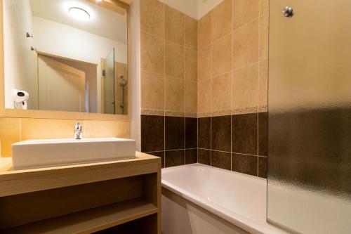 une salle de bain avec un lavabo, une baignoire et un miroir dans l'établissement Résidence Les Terrasses Du Soleil D'or - Appartement chaleureux avec terrasse vue pistes MAE-6864, aux Orres