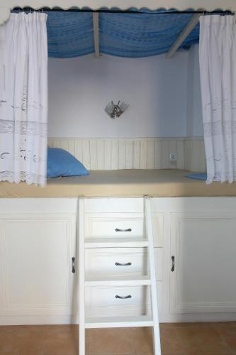 a bunk bed with a ladder under a window at Vicky's Studios in Órmos Aiyialís